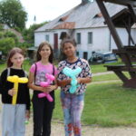 trzy dziewczynki stoją trzymając balony w ręce