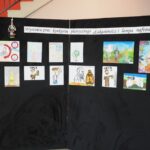 wystawa prac konkursu plastycznego "Łukasiewicz i lampa naftowa" na czarnym tle rysunki kolorowe dzieci