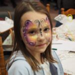 dziewczynka z pomalowaną na kolorowo twarzą