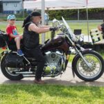 mężczyzna z dzieckiem na motocyklu