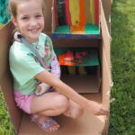 dziecko siedzi w pomalowym kartonie