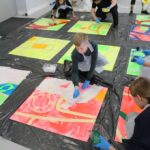 dzieic malują farbami kolorowe plansze